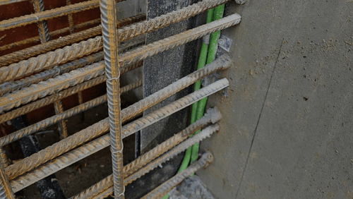 Detalj av armeringsjern og betong med elektriske kabler montert i konstruksjonen.